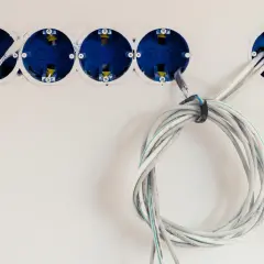 Instalacja elektryczna w trakcie. Widoczne puszki podtynkowe i przygotowane do podłączenia kable. Dowiedz się, jak podłączyć kabel 3 żyłowy do wtyczki.