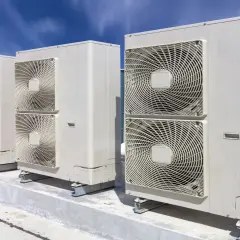 Jednostki klimatyzacyjne na dachu pod błękitnym niebem.