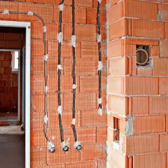 Nowe przewody elektryczne prowadzone po powierzchni ścian z pustaków ceramicznych, umożliwiające wymianę instalacji elektrycznej bez kucia.