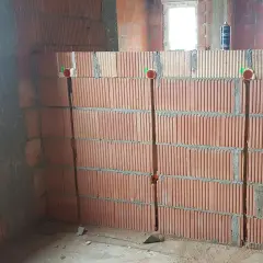 Bruzdowanie pod kable cena. Ściana z pustaków ceramicznych z wyciętymi bruzdami i puszkami instalacyjnymi.