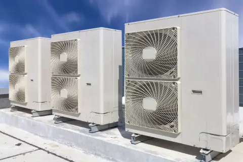 Jednostki klimatyzacyjne na dachu pod błękitnym niebem.