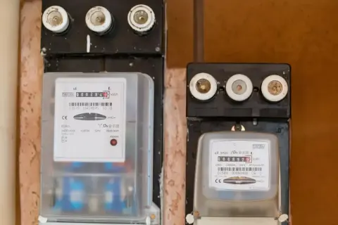 Dwa liczniki energii elektrycznej, jeden z nich to tauron elicznik, pokazują zużycie prądu.