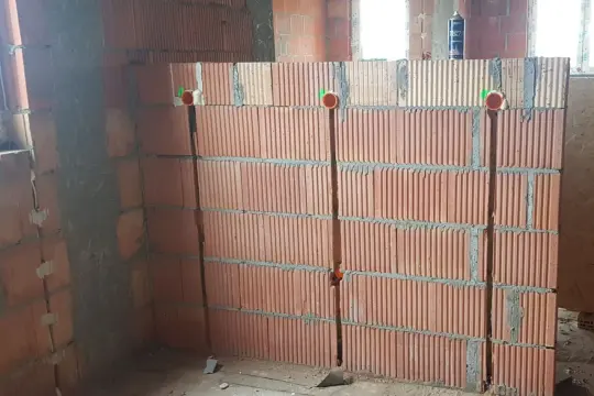 Bruzdowanie pod kable cena. Ściana z pustaków ceramicznych z wyciętymi bruzdami i puszkami instalacyjnymi.