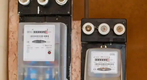 Dwa liczniki energii elektrycznej, jeden z nich to tauron elicznik, pokazują zużycie prądu.