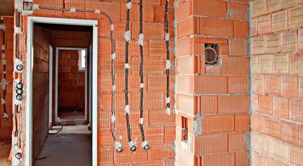 Nowe przewody elektryczne prowadzone po powierzchni ścian z pustaków ceramicznych, umożliwiające wymianę instalacji elektrycznej bez kucia.