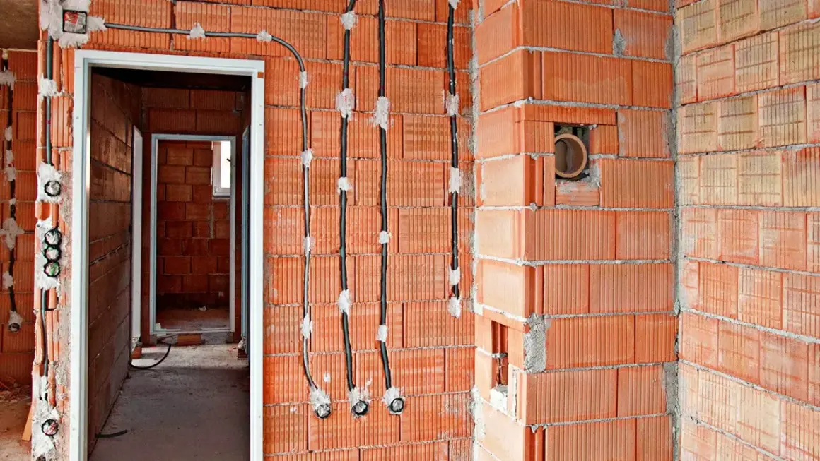Nowe przewody elektryczne prowadzone po powierzchni ścian z pustaków ceramicznych, umożliwiające wymianę instalacji elektrycznej bez kucia.