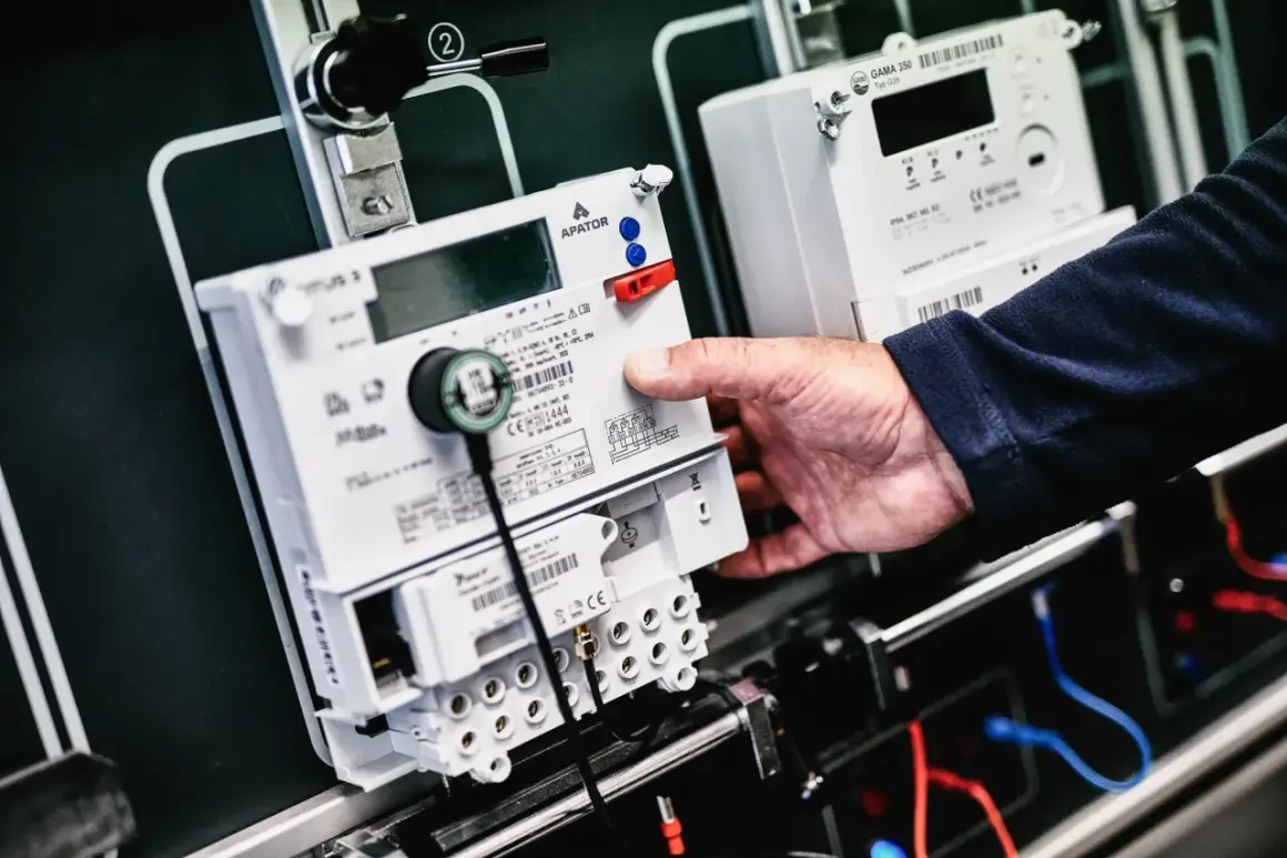 Dłoń manipuluje przy liczniku energii elektrycznej, przygotowując go do przepisania licznika PGE.