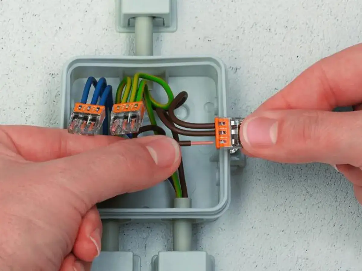 Pokazano, jak stosować złączki Wago do łączenia przewodów elektrycznych w puszce.