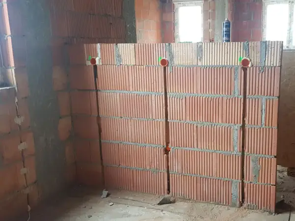 Bruzdowanie pod kable cena. Ściana z pustaków ceramicznych z wyciętymi bruzdami i puszkami instalacyjnymi.
